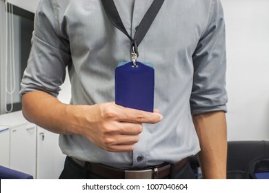 Close Up Businessman With Grey Shirt Hold Neck Company Badge In Office