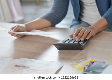 Close up businessman hand calculating monthly expense and credit card debt. - Shutterstock ID 1222156681