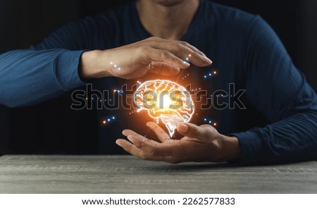 Close up of businessman hand holding brain in palm, Virtual reality man with symbol neurons in the brain. Concept of idea and innovation, on wooden table.