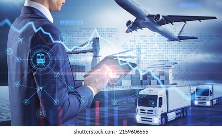 Close up of businessman hand holding tablet or smartphone with abstract glowing shipping hologram on dock with transport background. Export, logistics and freight concept. Double exposure - Powered by Shutterstock