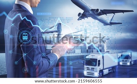 Close up of businessman hand holding tablet or smartphone with abstract glowing shipping hologram on dock with transport background. Export, logistics and freight concept. Double exposure