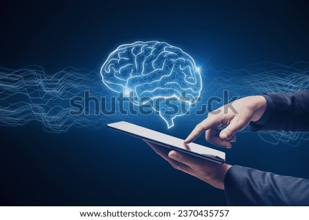Close up of businessman hand pointing at cellphone with creative digital brain hologram on blue background. Hi-tech innovation and AI concept