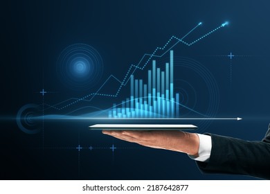 Close up of businessman hand pointing at tablet with abstract glowing polygonal business graph hologram with growing arrow on blurry background. Financial growth, market and trade concept
