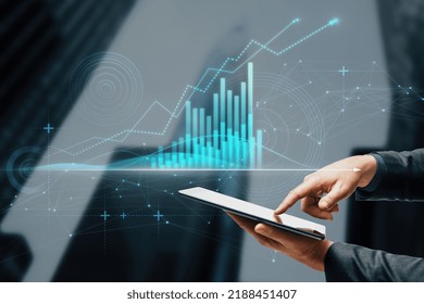 Close Up Of Businessman Hand Pointing At Tablet With Abstract Glowing Polygonal Business Graph Hologram With Growing Arrow On Blurry City Background. Financial Growth, Market And Trade Concept