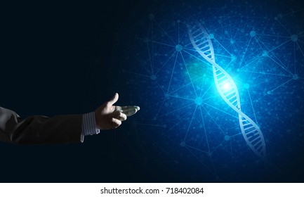 Close of businessman hand presenting DNA molecule research as concept. Mixed media - Shutterstock ID 718402084