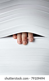 close up of businessman hand in stack of papers