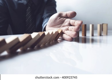 Close up of businessman hand stop dominoes continuous toppled vintage tone.