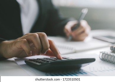 Close up businessman hand using calculator and writing make note with calculate about finance accounting.finance accounting concept
