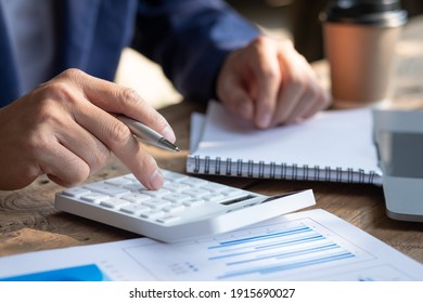 Close Up Businessman Hand Using Calculator And Working With  Laptop Calculate About Finance Accounting At Coffeeshop Outdor.finance Accounting Concept
