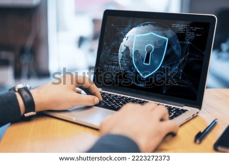 Close up of businessman hand using laptop keyboard at wooden desktop with abstract safety hologram with globe and coding on blurry background. Secure, protection and web concept. Double exposure