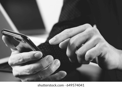 Close Up Of Businessman Hand Working With Mobile Phone And Laptop And Digital Tablet Computer In Modern Office,black And White