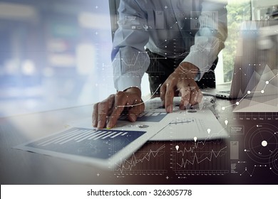 close up of businessman hand working on laptop computer with financial business graph information diagram on wooden desk as concept
