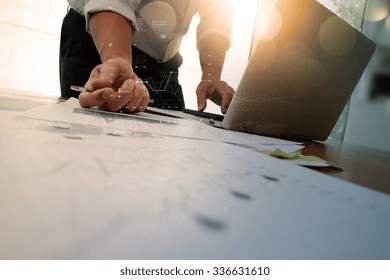 Close Up Of Businessman Hand Working On Laptop Computer With Business Graph Information Diagram On Wooden Desk As Concept