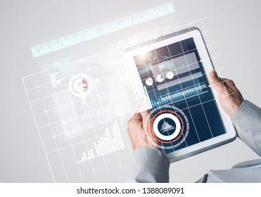 Close of businessman hands holding tablet pc with infographs on screen - Shutterstock ID 1388089091