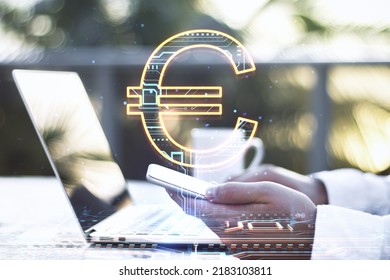 Close up of businessman hands using laptop keyboard and smartphone on desktop with creative glowing euro sign hologram on blurry outdoor background. Online banking, technology and currency concept - Powered by Shutterstock