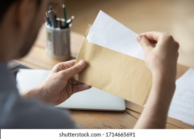 Close Up Businessman Holding Envelope With Blank Paper Sheet, Focused Man Looking At Letter, Received News, Notification Or Invitation, Working With Correspondence, Sitting At Work Desk