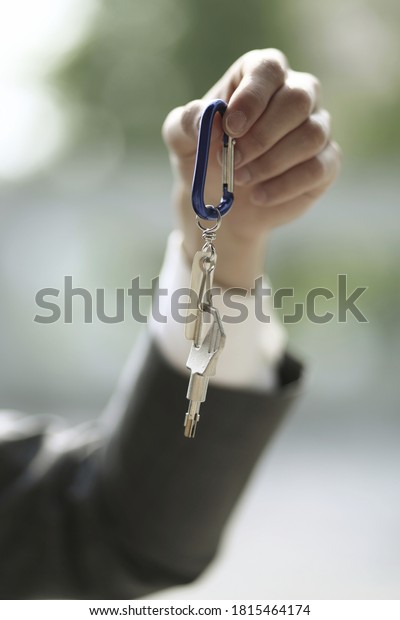 Close up\
of businessman holding key ring and key \
\
