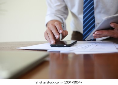 Close up Businessman holding pen at financial on wooden desk in home office. analytic research concept. - Shutterstock ID 1304730547