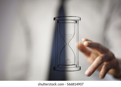Close up of businessman holding sandglass in hand - Shutterstock ID 566814907