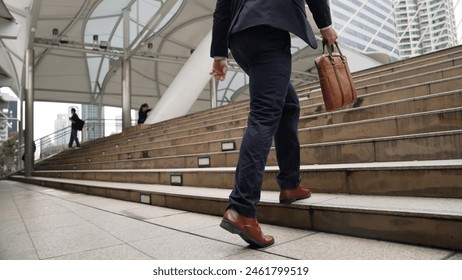 Close up of businessman leg walking up stairs surrounded by urban view. Back view of ambitious project manager finding challenging job or investment opportunity at city with modern building. Urbane. - Powered by Shutterstock