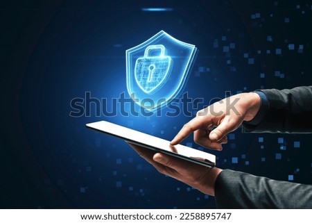 Close up of businessman pointing at cellphone with glowing padlock hologram on dark blurry background. Secure, safety and web concept