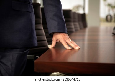 Close Up Of Businessman In Suit Resting His Hand On A Conference Room Table 