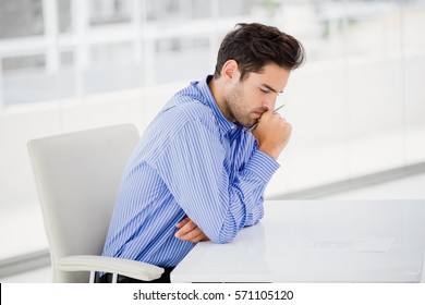 Close up of businessman thinking and writing on paper in office - Powered by Shutterstock