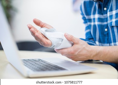 Close Up Of Businessman Using Laptop Suffering From Repetitive Strain Injury (RSI)