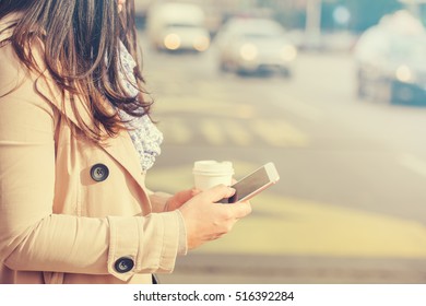 Close Up Of Businesswoman Checking Email Via Mobile Phone And Holding A Coffee Cup.