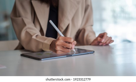 Close up of businesswoman hand are working on the tablet at office. - Powered by Shutterstock