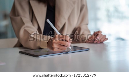 Close up of businesswoman hand are working on the tablet at office.