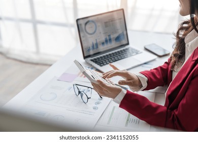 Close up of businesswoman hands using a calculator to check company finances and earnings and budget. Business woman calculating monthly expenses, managing budget, papers, loan documents, invoices
