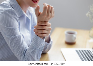 Close Up Businesswoman Holding Hand Feeling Wrist Pain From Using Laptop Long Time. Young Employee Suffering Carpal Tunnel Syndrome From Intensely Using Mouse And Typing On Keyboard. Computer Overwork