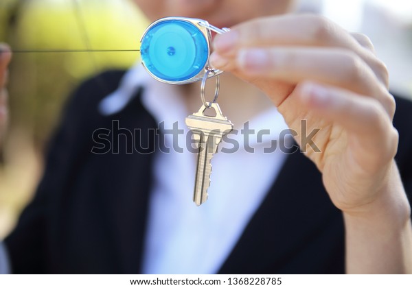 Close up of\
businesswoman holding key ring and\
key