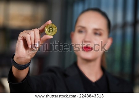 close up businesswoman holding and showing golden bitcoin cryptocurrency on hand