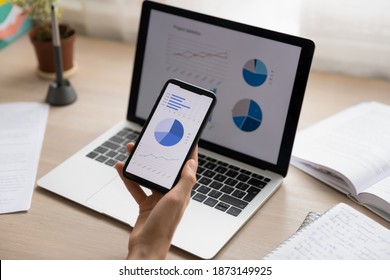 Close up businesswoman holding working with project statistics on devices, presentation with graphs and diagrams on laptop and phone screens, entrepreneur accountant analyzing financial data - Powered by Shutterstock