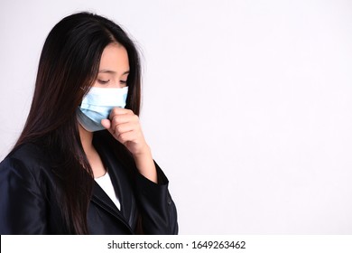 Close up of a businesswoman in a suit wearing Protective face mask and cough, get ready for Coronavirus and pm 2.5 fighting against on gray background. - Powered by Shutterstock