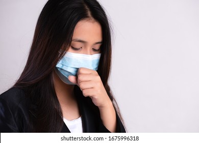 Close up of a businesswoman in a suit wearing Protective face mask and cough, get ready for Coronavirus and pm 2.5 fighting against on gray background. - Powered by Shutterstock