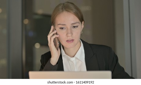 The Close Up of Businesswoman talking on Phone on Office Desk at Night
