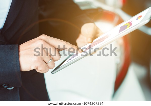Close up businesswoman is using a tablet with\
a car background