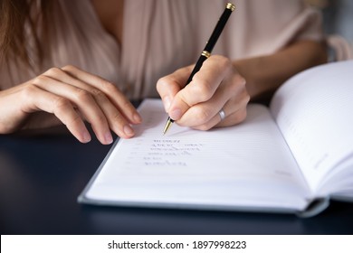 Close up businesswoman writing in notebook, planning workday, meetings, entrepreneur managing time, sitting at table, student making note during lecture, preparing for exam, handwriting