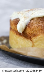 Close Up Of Buttercream Frosting On Cinnamon Roll Cake, White Background, Grey Marble Table