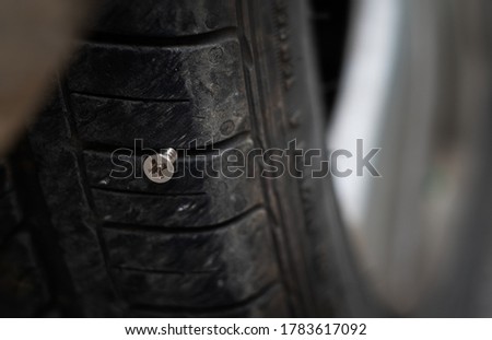 Close up button head needle metal screw nail stuck to puncture into wheel tire