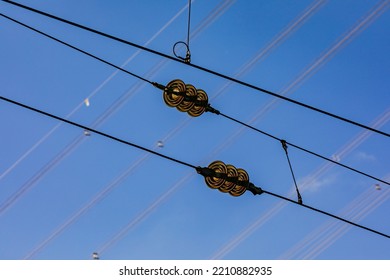 Close Up Of Cables Of Overhead Line For Railroad With Insulators And Power Line In Background