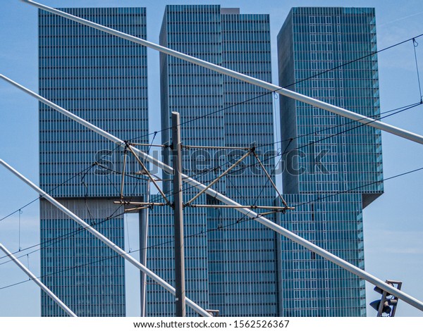 Close up of cables ties of the Erasmus\
cable-stayed bridge and and electricity cables, with the Rem\
Koolhaas office building in the background, cloudy day in\
Rotterdam, the Netherlands\
Holland