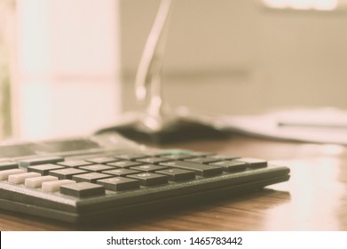 Close up of a calculator placed on office desk. A loan application form at a distance. Business Finance Concept. Vintage background. Isolated. Copy space room for text. - Powered by Shutterstock - Get 15% off with code: PIKWIZARD15