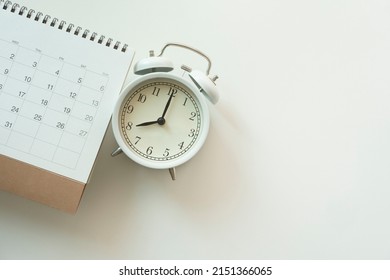 close up of calendar and alarm clock on the white table background, planning for business meeting or travel planning concept - Shutterstock ID 2151366065