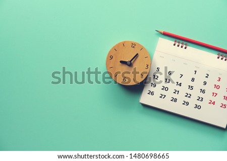 close up of calendar and alarm clock on the green table, planning for business meeting or travel planning concept