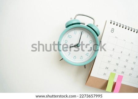 close up of calendar and alarm clock on the white table background, planning for business meeting or travel planning concept