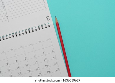 close up of calendar and pencil on the green table background, planning for business meeting or travel planning concept